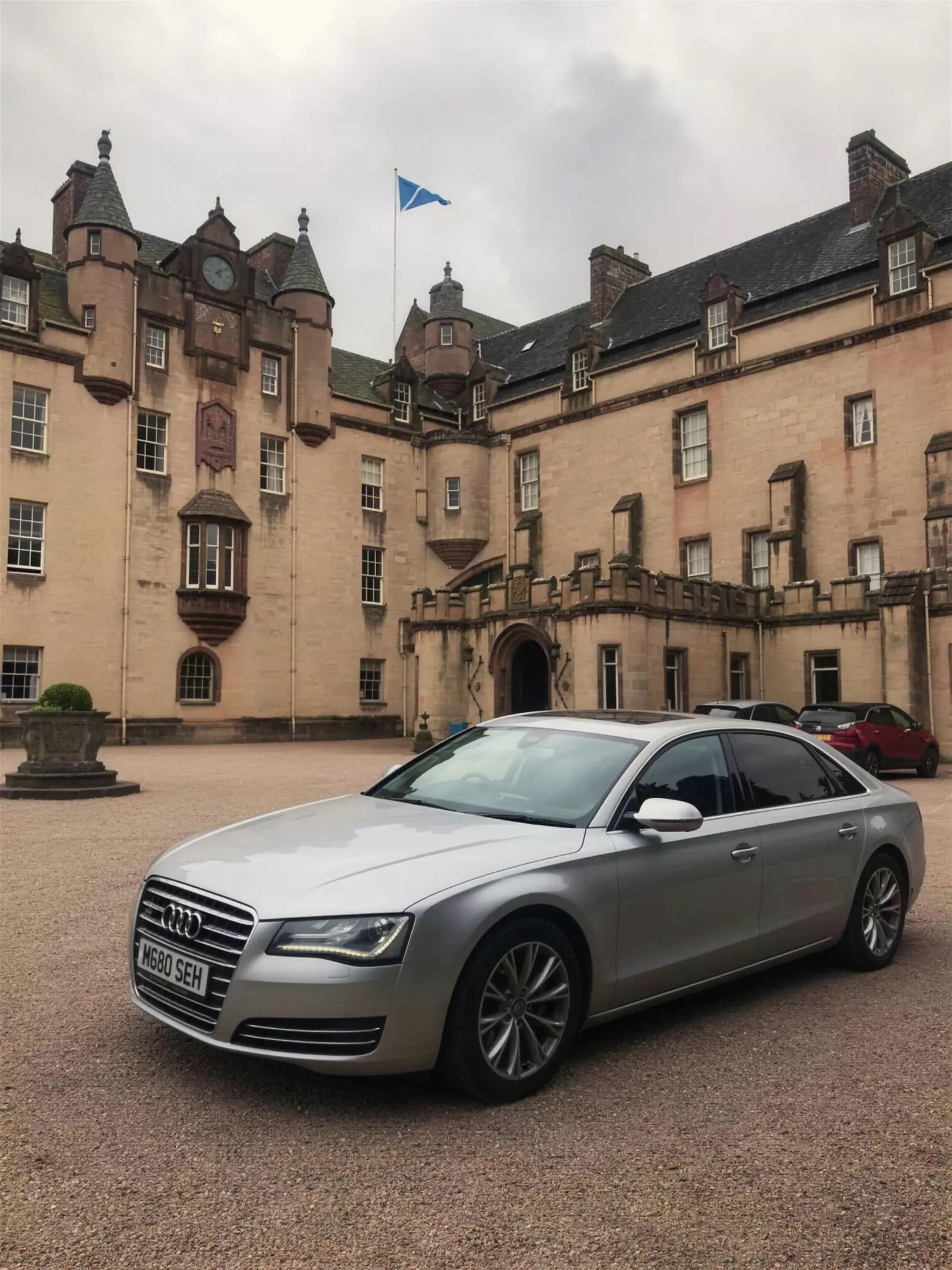 Audi A8 L in front of a pink sandstone castle